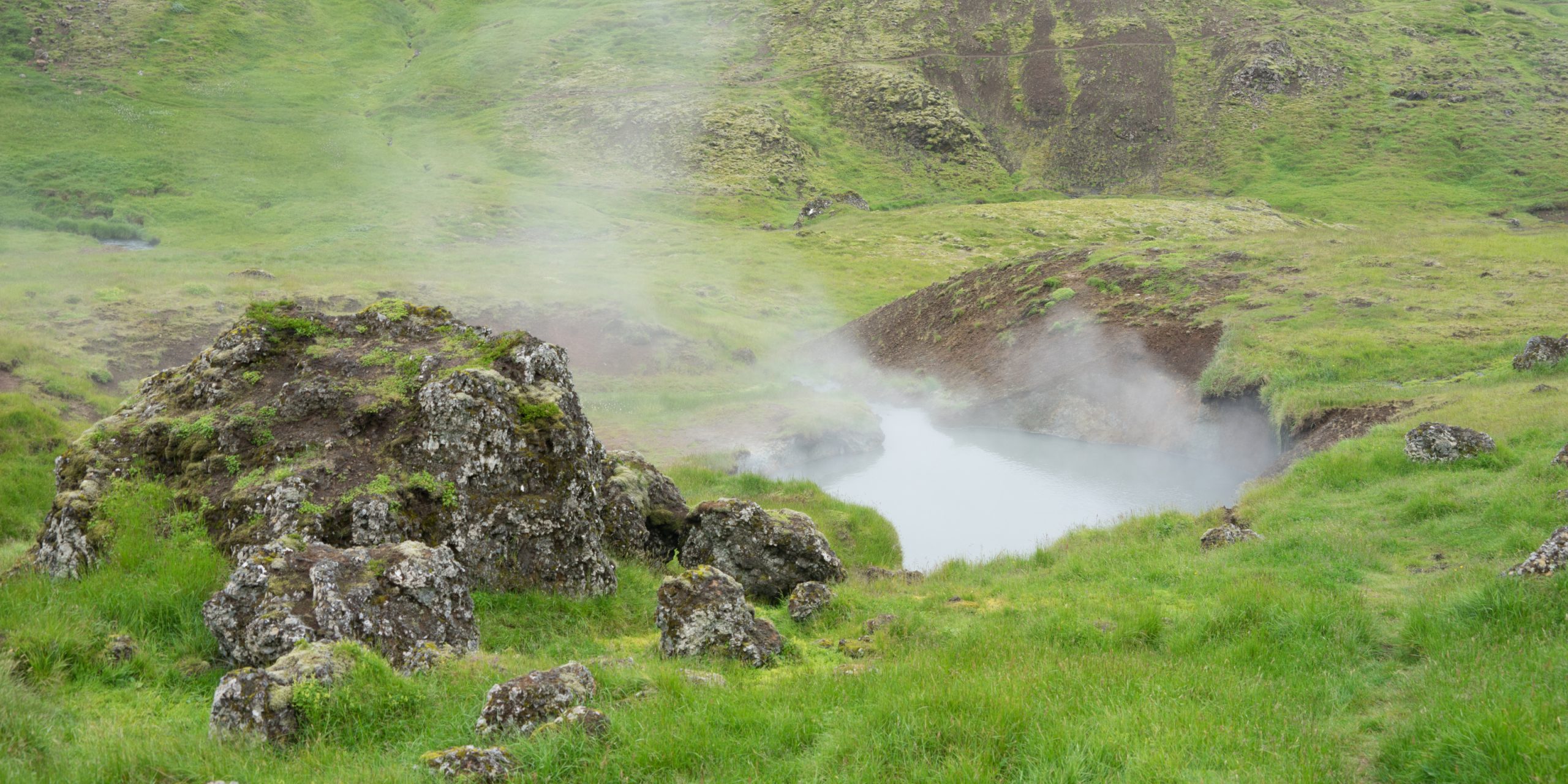 Landschaft mit heißen Quellen und Wasserfällen im Hengill Geot